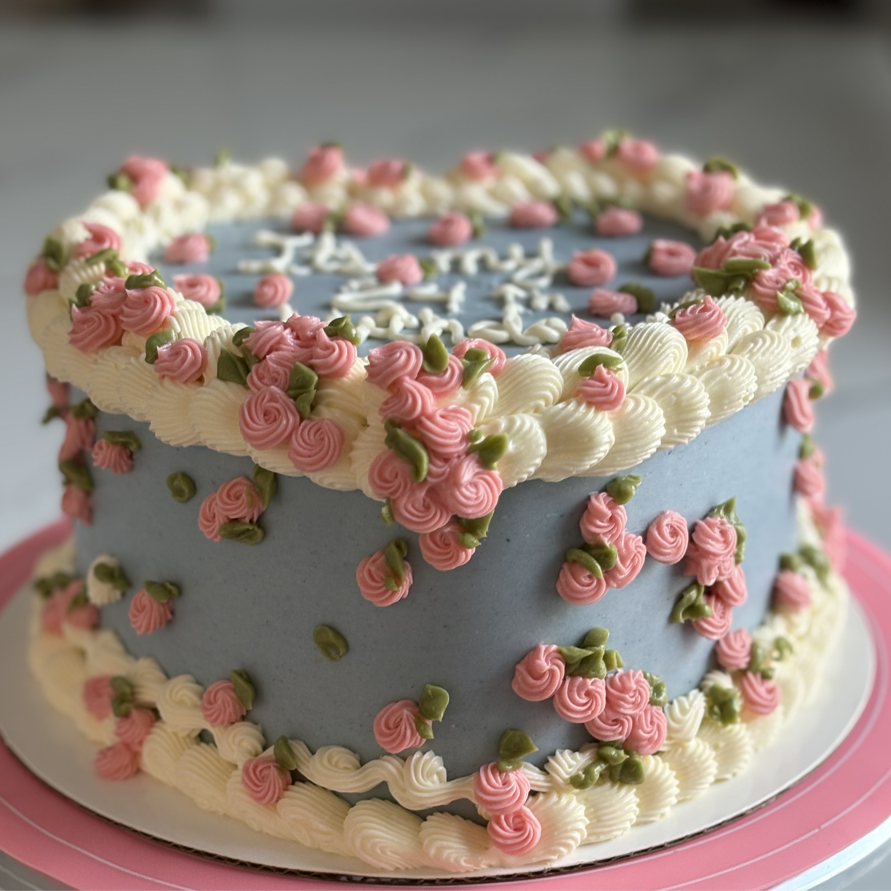 Pastel mediano azul con rosas de crema