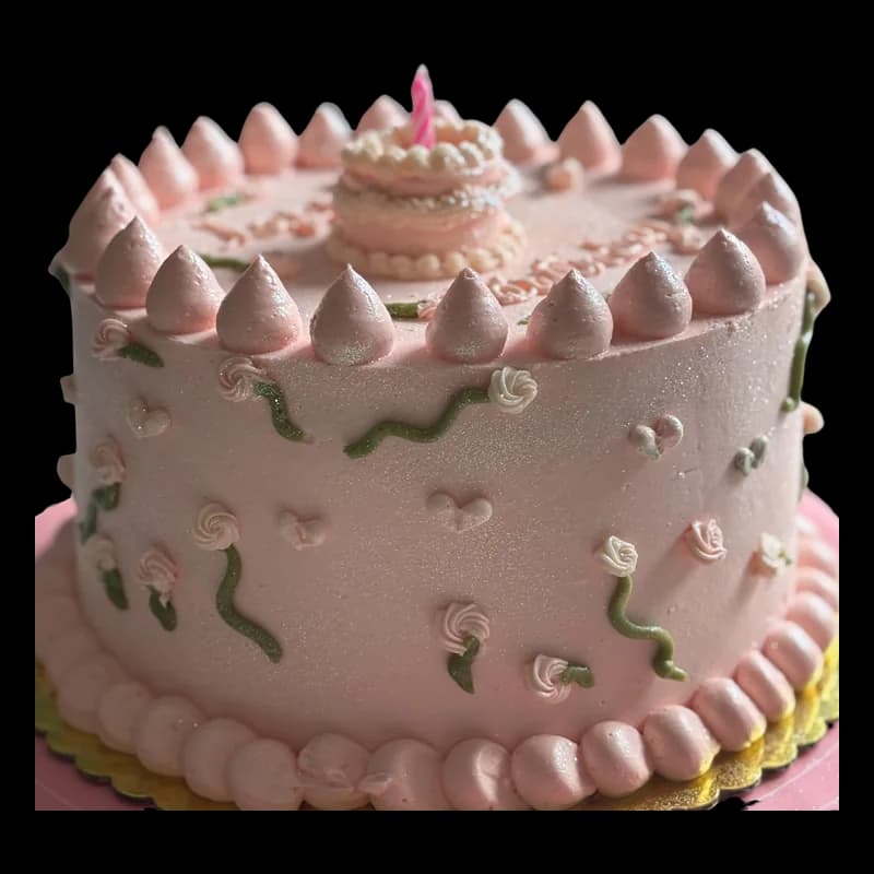 Pastel rosa con picos de crema, rositas y hojas verdes
